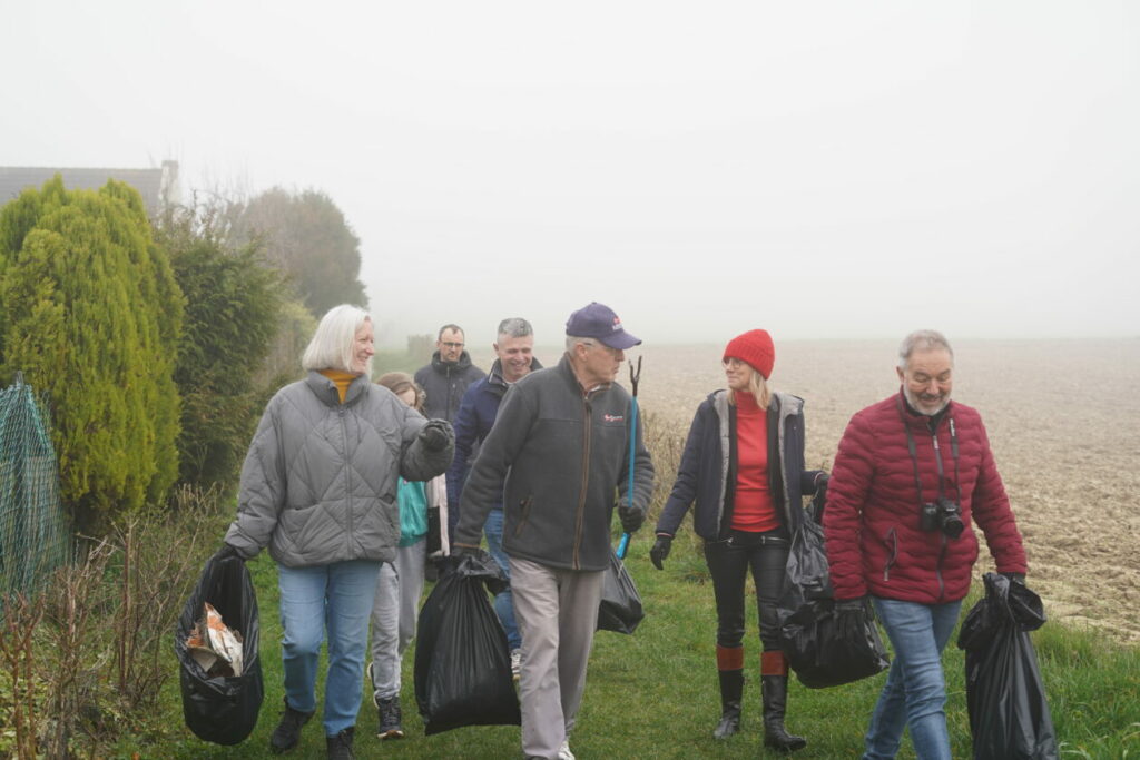 Un groupe de personnes, dont Agnès Pannier-Runacher, est muni de sacs poubelles et participe au nettoyage des rues dans le Pas-de-Calais.
