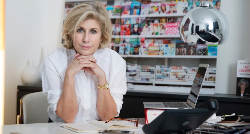 Photo de Patricia Chapelotte, présidente fondatrice du Prix de la Femme d’Influence assise à un bureau